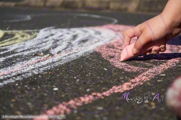 Kind malt mit Kreide auf Asphalt