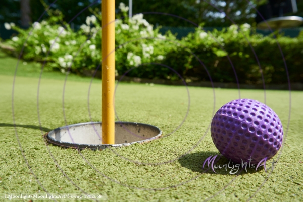 Minigolf - Ball liegt vor dem Loch